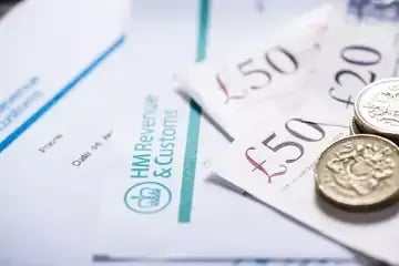 HMRC Forms with pound coins and £50 notes