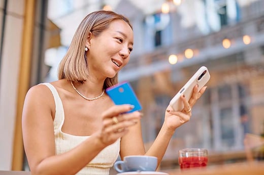 woman using credit card and phone